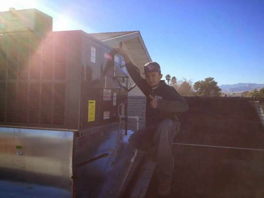 HVAC technician performing Heat Pump Repair on a rooftop unit in Bel Aire